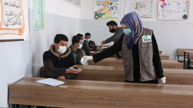 In cooperation with the Free University of Aleppo, student volunteers distribute medical masks and hand sanitizer to students sitting for exams. March 2021. Credits: Free University of Aleppo